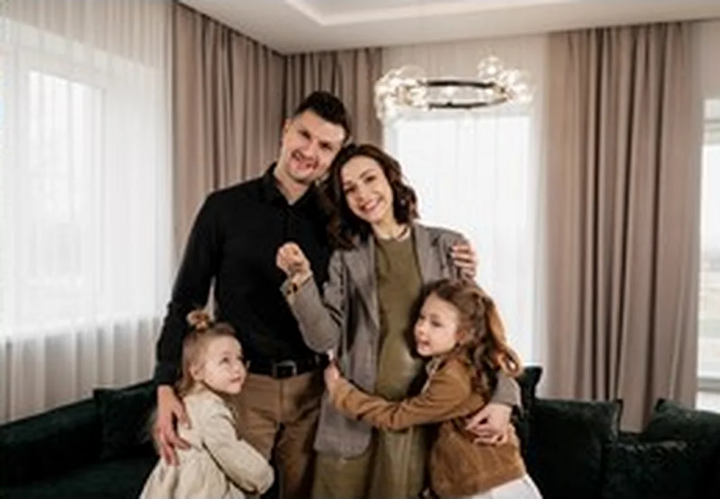 Familie mit Hausschlüssel vor einer neuen Wohnphase